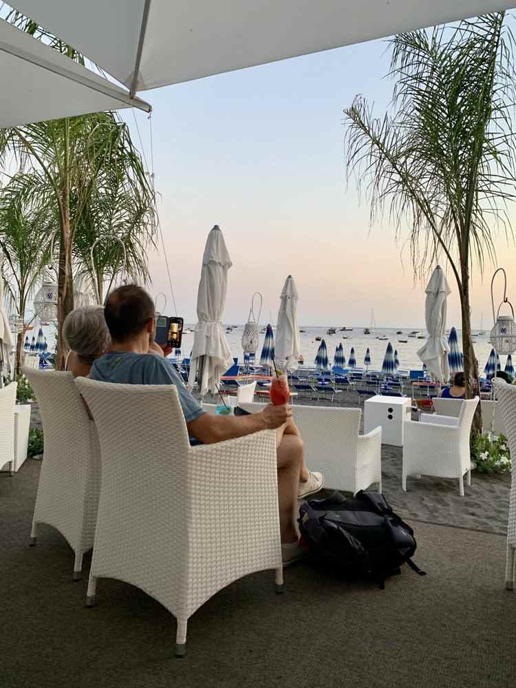 poltroncine vicino al mare in spiaggia durante il tramonto